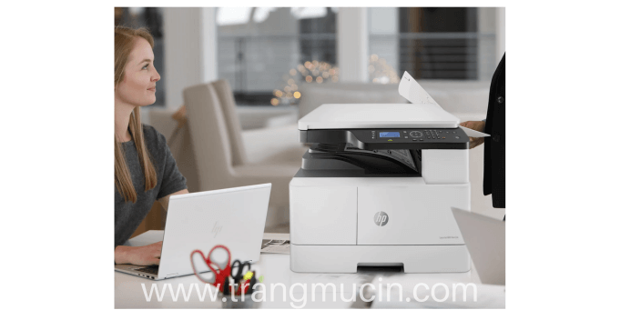 đặt máy in laser hp laserjet pro mfp m42623dn cạnh hai chiếc laptop 